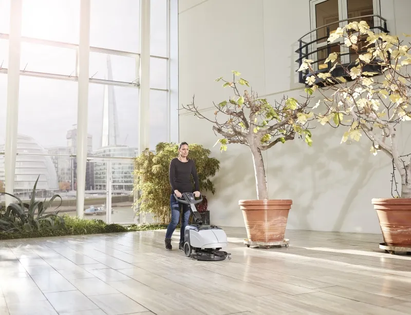 Person som bruker en maskin til vaske/bone gulvet