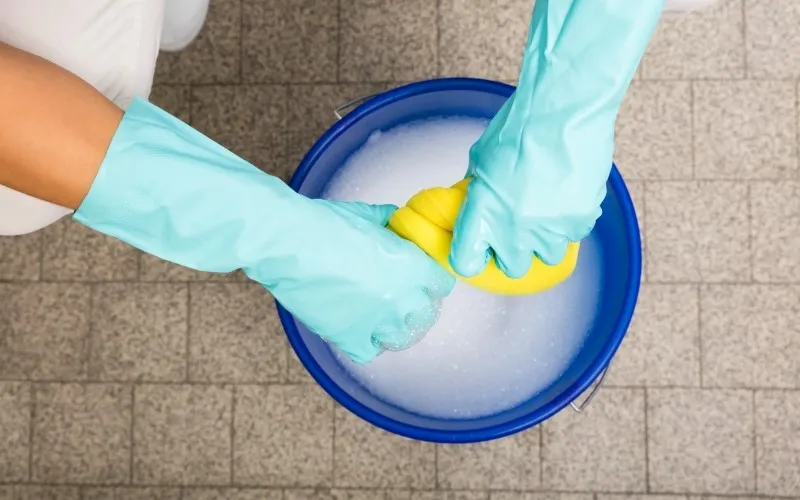 En person som vrir opp en svamp over en bøtte