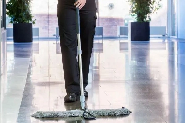 Mann som vasker vindu på en skyskraper