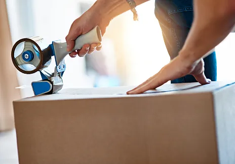 En person som teiper en pappeske