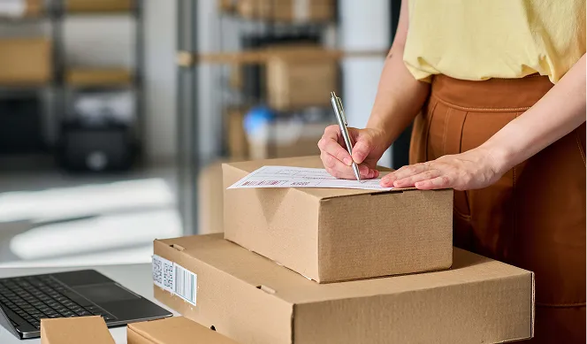 En person somskriver på en lapp på en pappeske