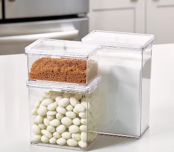 3 opbevaringsbokser på ett kjøkkenbord med brunt sukker, mel og andre ting