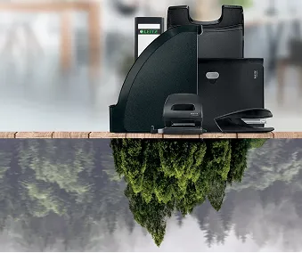 Diverse kontorrekvisita plassert på et bord, hvor under bordet de er speilet i en skog