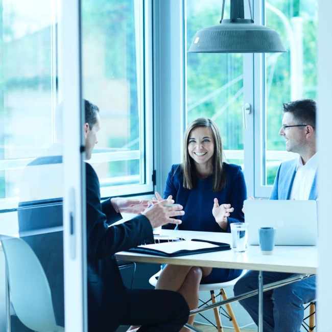 People around desk in brightly lit office