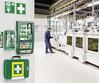 En vegg med førstehjelpsskap og påfyll i ett industrielt miljø