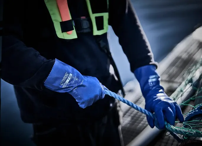 En person med engangshansker som kutter en biff