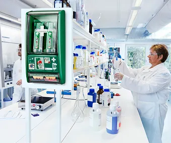 Ett laboratorium hvor mennesker jobber og ett øyerens sett hengende på veggen