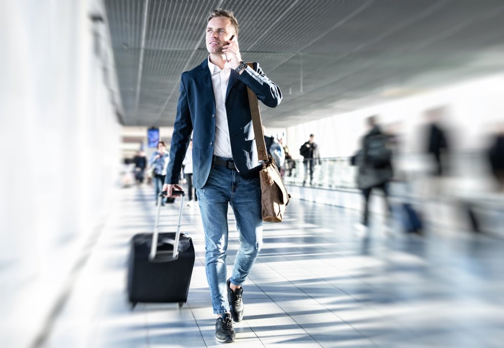 Mann triller koffert gjennom flyplassterminal