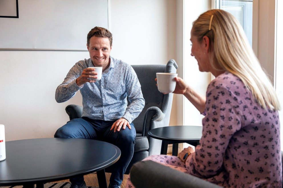 To kollegaer har det hyggelig med kaffe