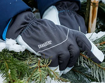 En person med arbeidshansker som holder noe granbar