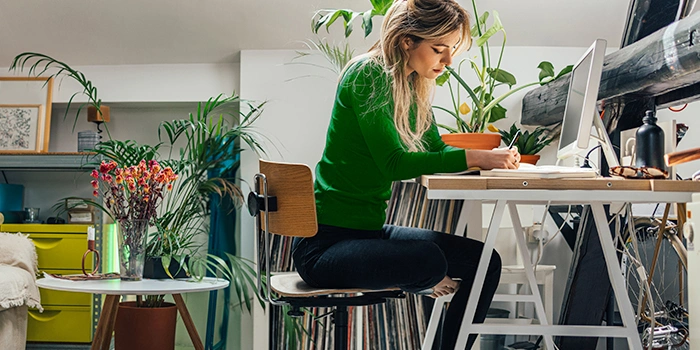 En person som skriver i en notatbok ved ett skrivebord