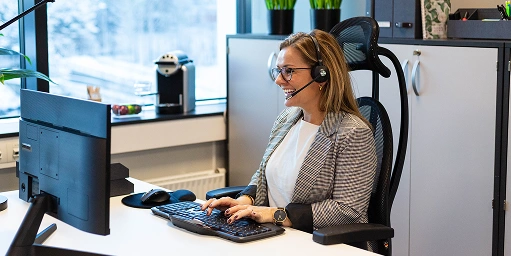 En person som jobber på ett kontor. Sitter ved skrivebordet.