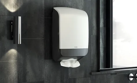En papirdispenser montert på en vegg i et offentlig toalett.
