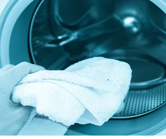 En person som vasker klær i en vaskemaskin