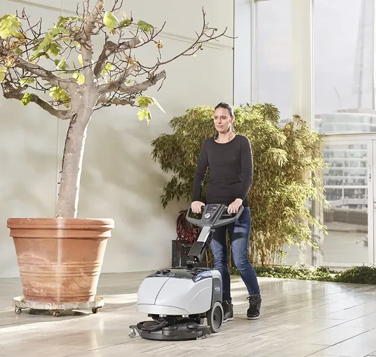 En person som bruker en maskin til å vaske ett gulv