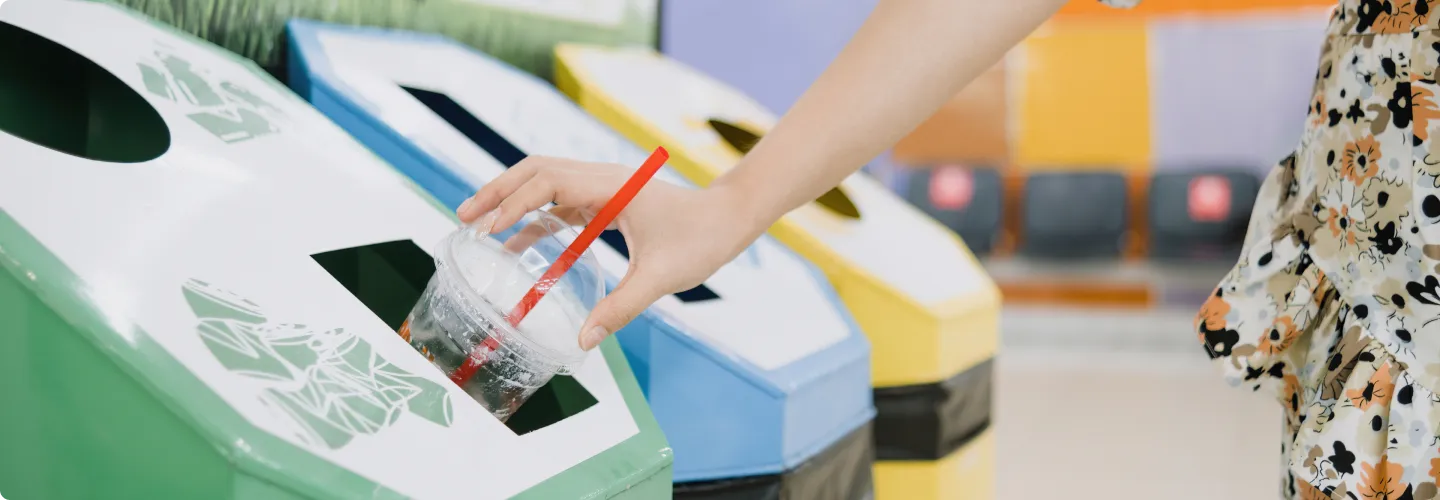 En person som som resirkulerer avfall i en avfallsbeholder for kildesortering