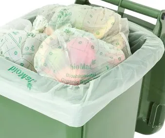 En søppel sekk ssom er fylt med fulle matavfallsposer i en søppelkonteiner for kildesortering