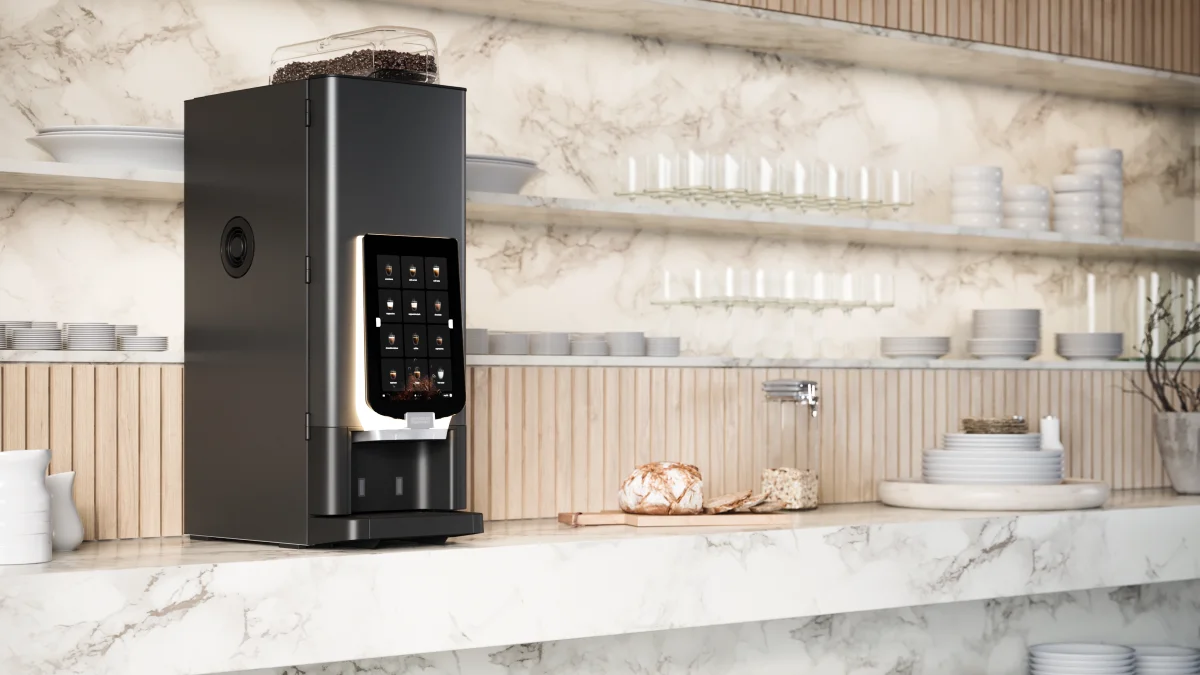 En FreshBrew-maskin som står på ett bardisk i marmor med tallerken, kopper og glass rundt
