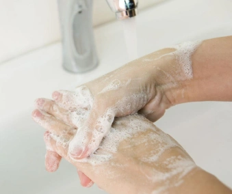 En person som vasker hendene med såpe