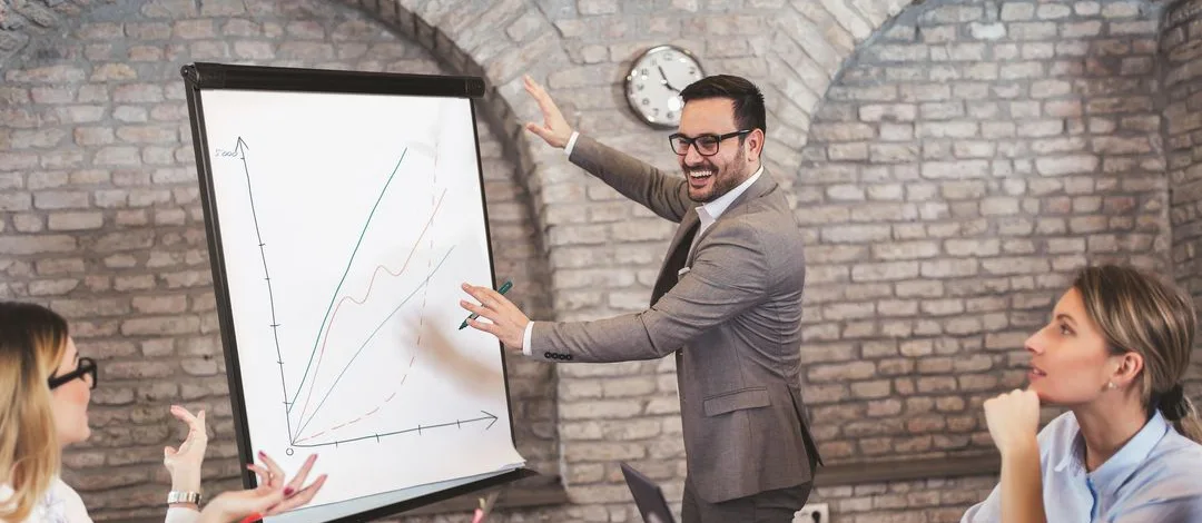 En person i ett møte som prater om ett diagram på en flippover 