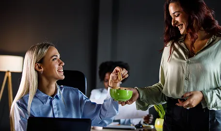 En person som får en te kopp av en annen