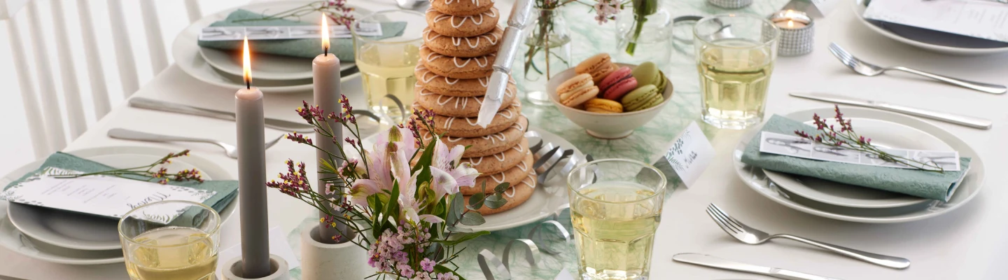 Pent dekket bord med tallerkener, glass og blomster