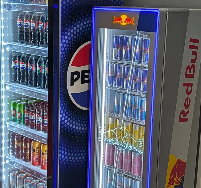 Kolleger bruker kaffemaskin på kontoret