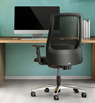 En kontorstol foran ett skrivebord med en pc skjerm