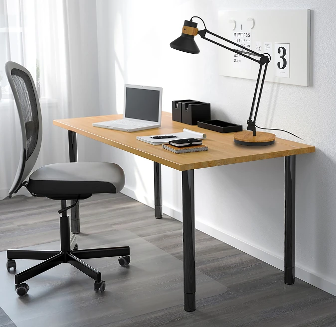 Ett hjemmekontor med kontorstol og skrivebord med lampe, laptop og diverse kontorrekvisita