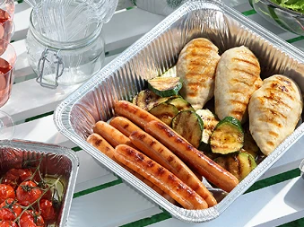 Bilde av flere cateringemballasje produkter med diverse mat i på en piknik bord