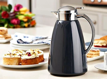 Bilde av en kaffekanne med masse kaker på bordet i bakgrunnen