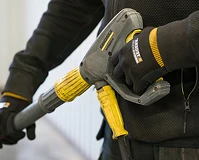 En person med hansker som holder en høytrykk spyler