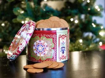 En pepperkake boks fra Nyåker på ett svart bord foran ett juletre