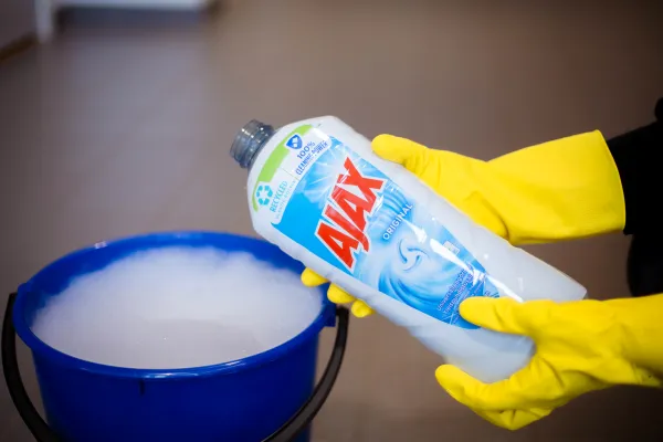 Ajax flaske foran en bøtte med såpeskum