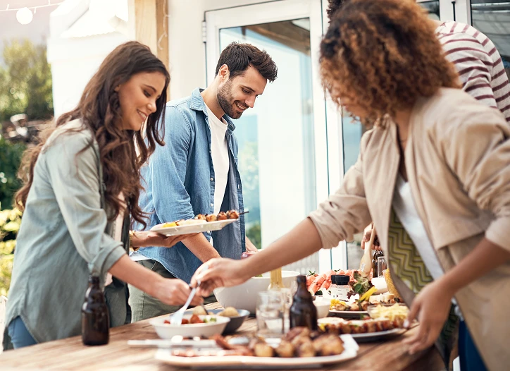 4 personer som forskyner seg av mat og drikke på en fest