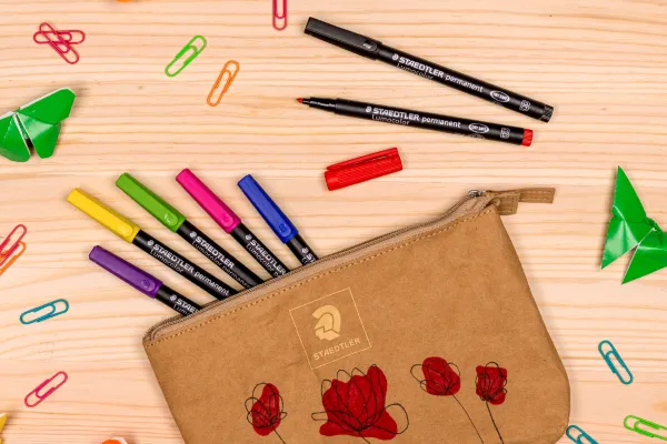 Mange farge rike Staedtler penner som har falt ut av ett penal med fargerike binderser overalt