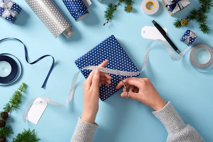 En person som pakker inn en julegave