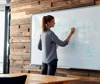 En person som skriver på en whiteboardtavle