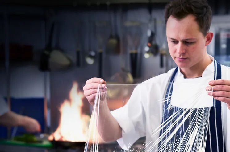 En kokk som holder plastfolie