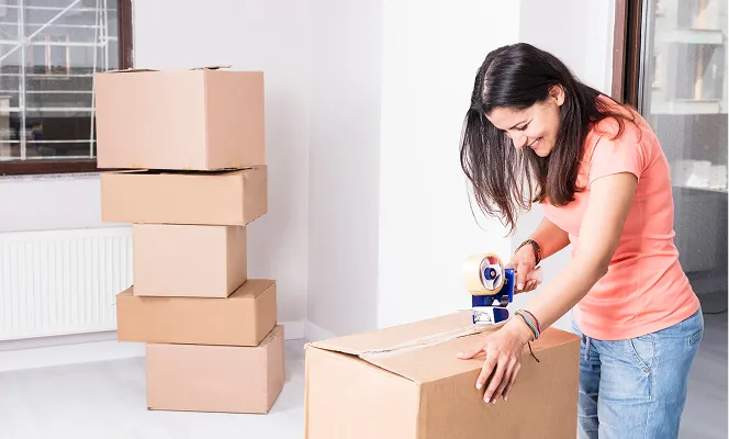 En person som teiper igjen en flytteeske